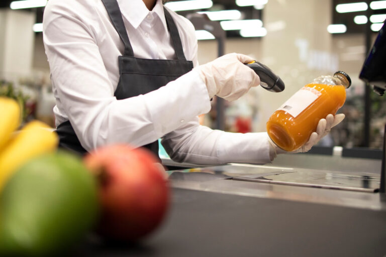 Operatore alla cassa scansiona un succo di frutta al supermercato