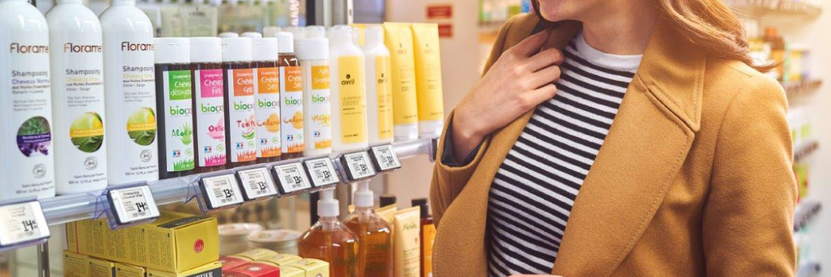 Acquirente donna davanti ad uno scaffale di prodotti cosmetici con etichette elettroniche nel supermercato